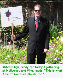 Mitch's sign reads, This is what Alberto Gonzales stands for, and shows the Abu-Graib captive balanced atop a bucket, wires attached to outstrethced hands, at the hands of the U.S. Government.